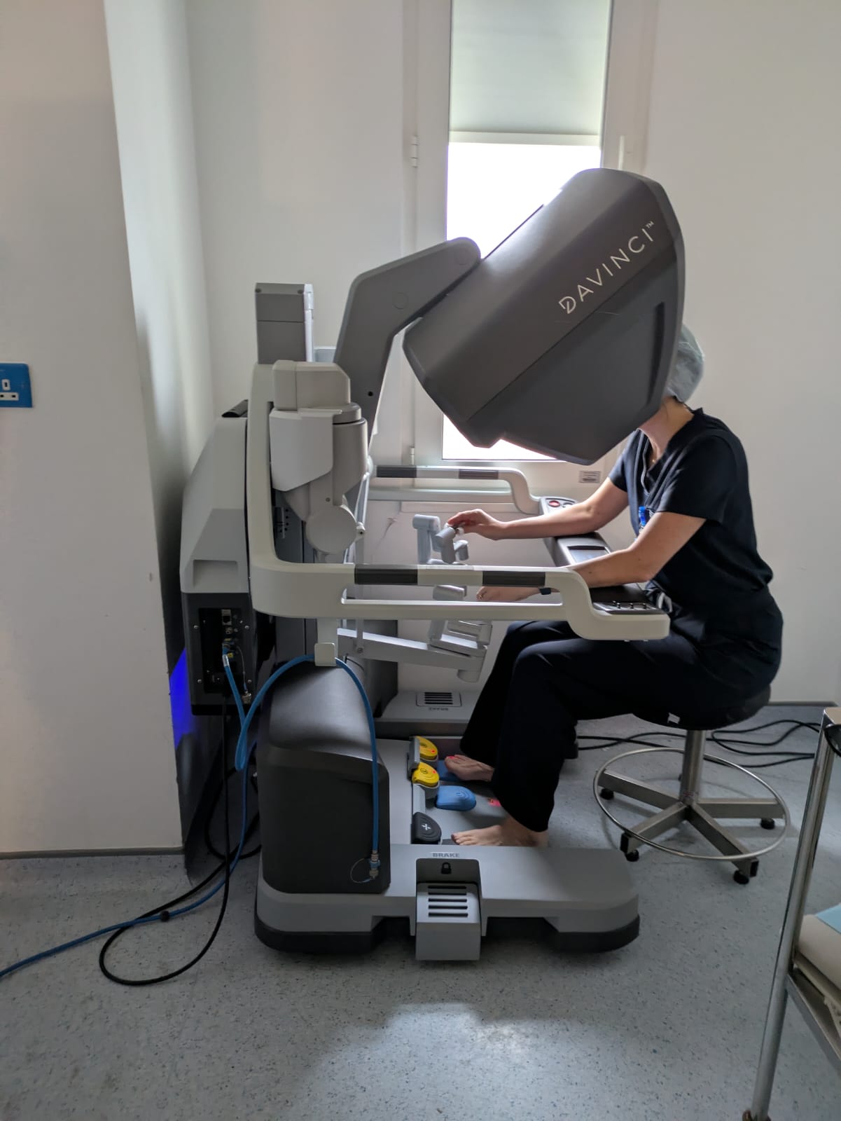Da Vinci robotic surgical system in an operating theatre with robotic arms over a draped patient