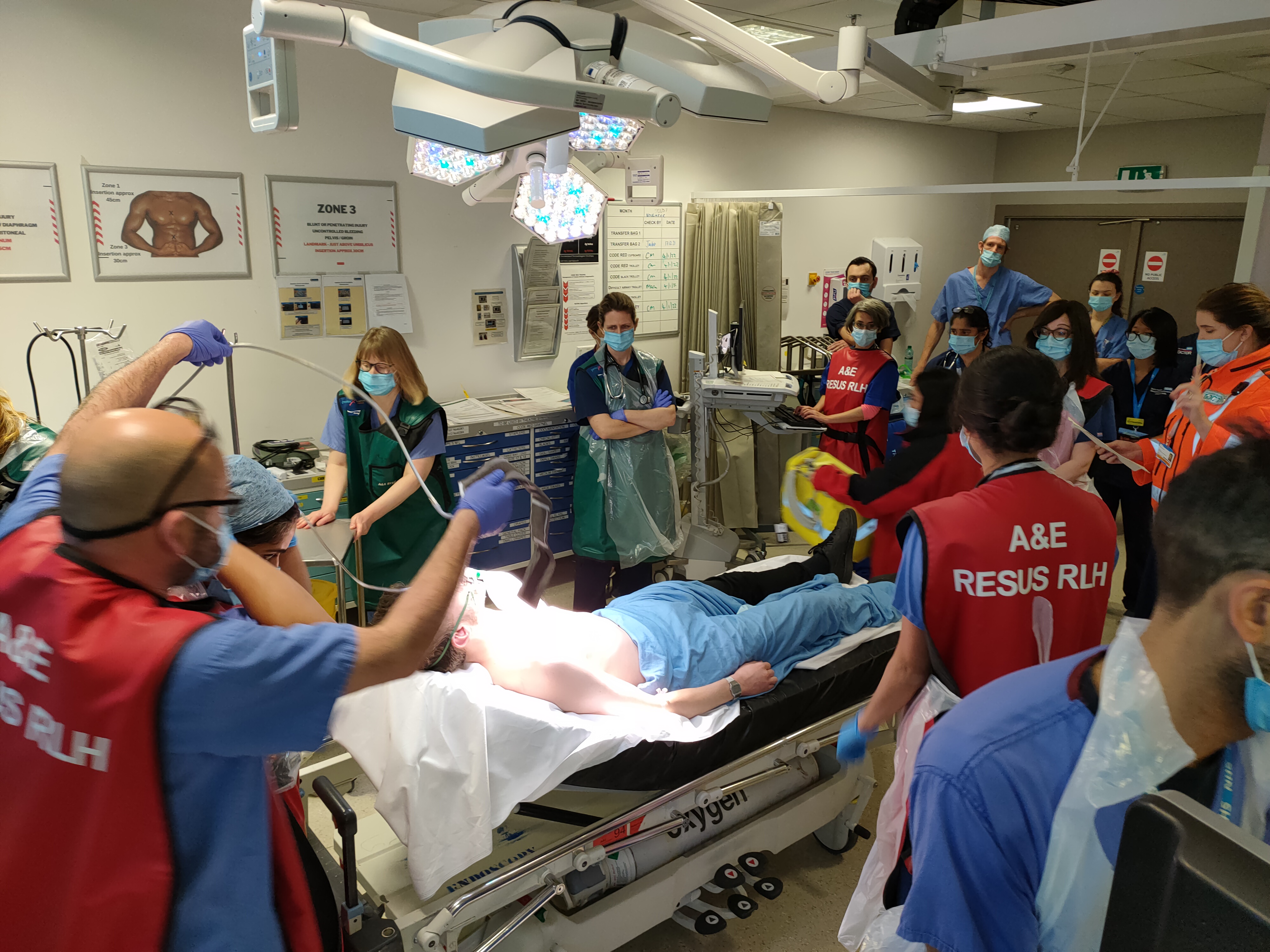 A&E resus team performing a trauma simulation on a manikin in a trauma bay