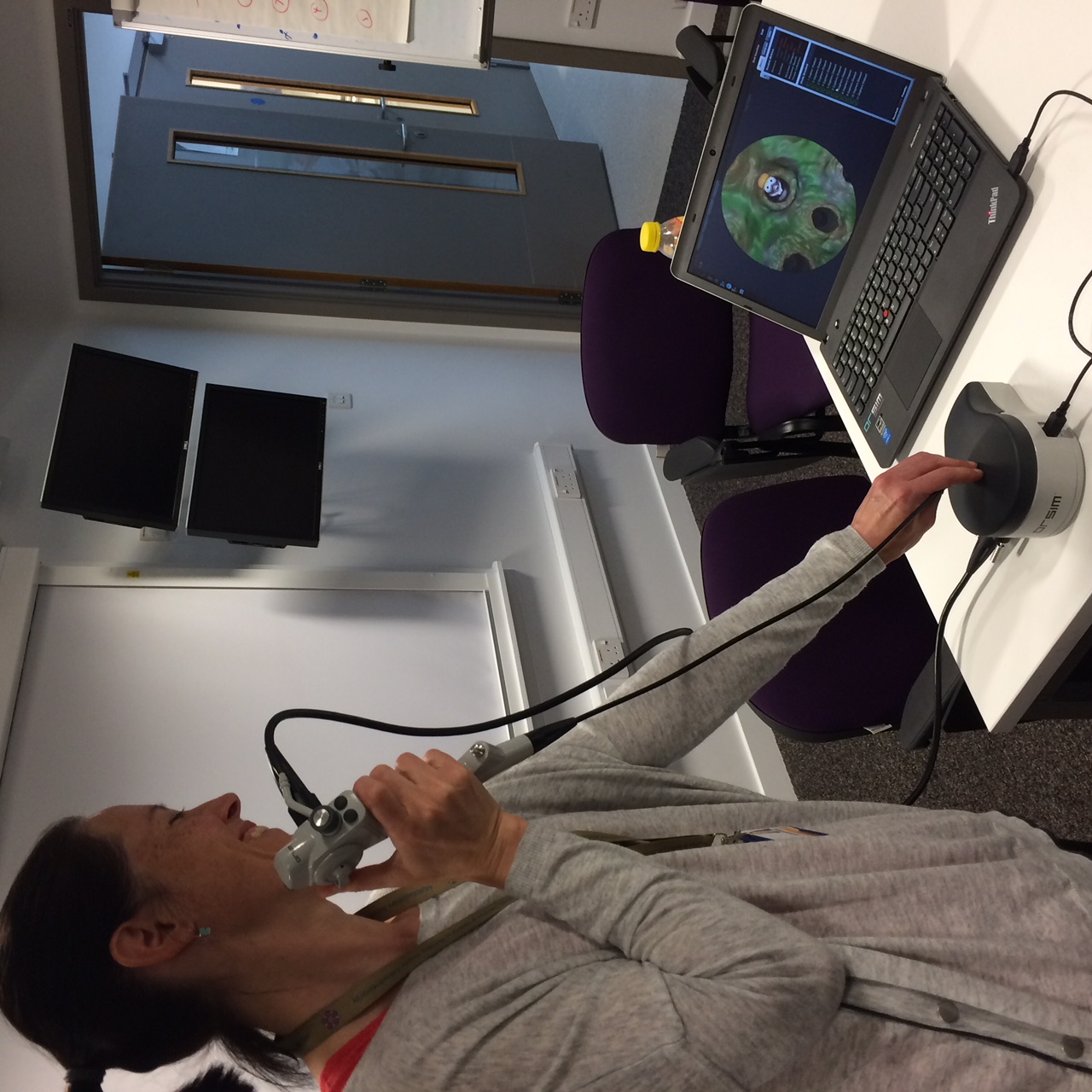 Faculty member using a bronchoscopy part-task trainer connected to a laptop simulation display